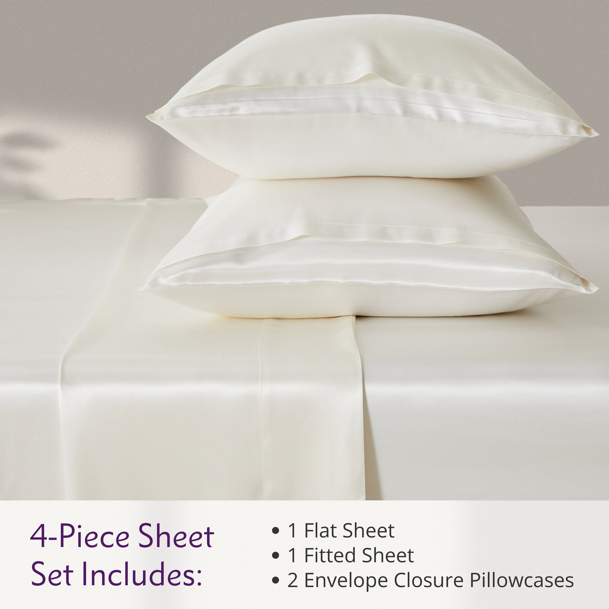 Ivory  4-piece silk sheet set with two pillowcases, a flat sheet, and a fitted sheet on a bed