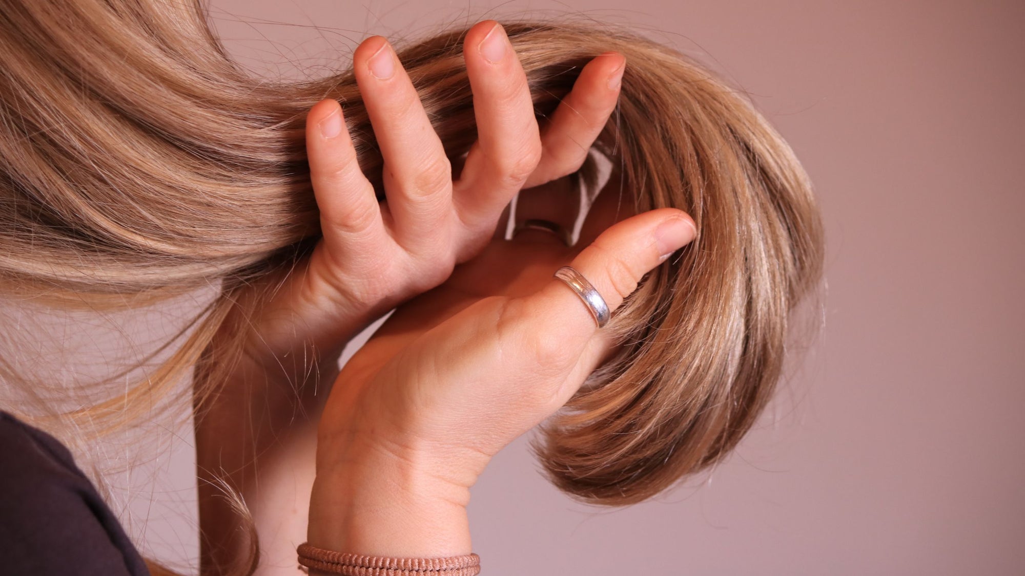 Woman holding a large chunk of healthy blonde hair