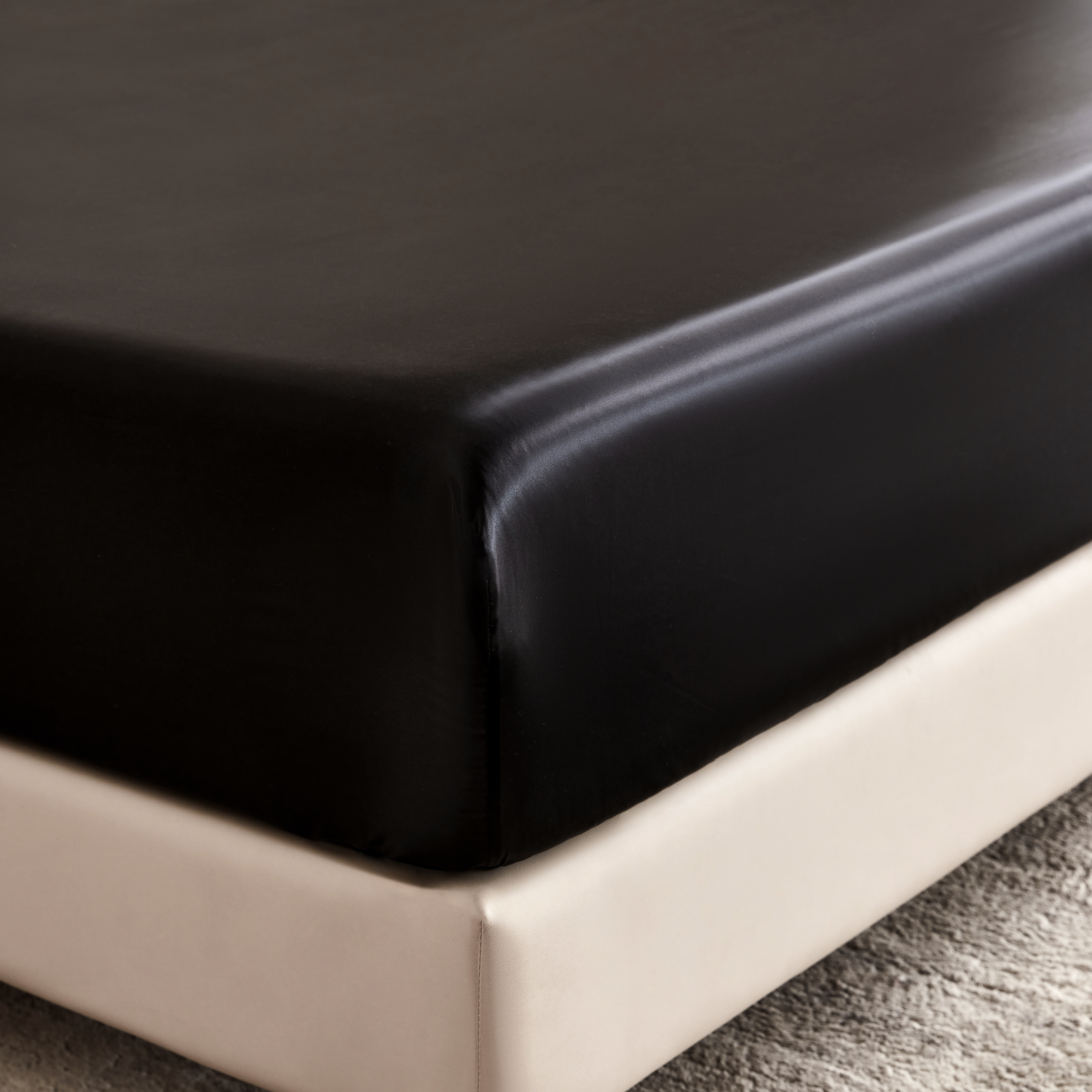 Black fitted sheet on a bed in a bedroom setting