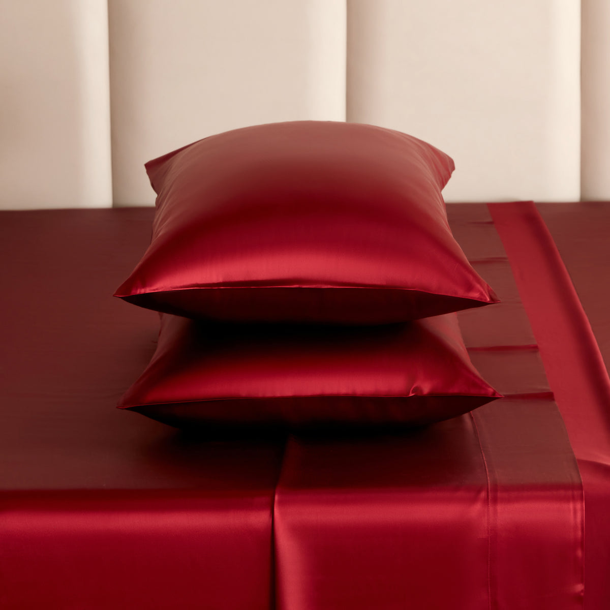 Red silk pillows on a matching red silk sheets underneath